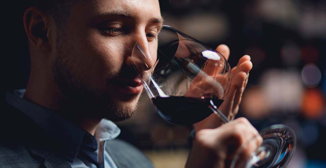 мужчина пьет вино из бокала
