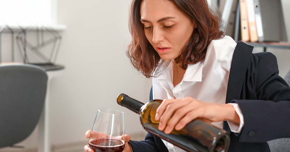 женщина наливает себе вино в бокал